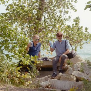 Two men enjoying drinks by the water